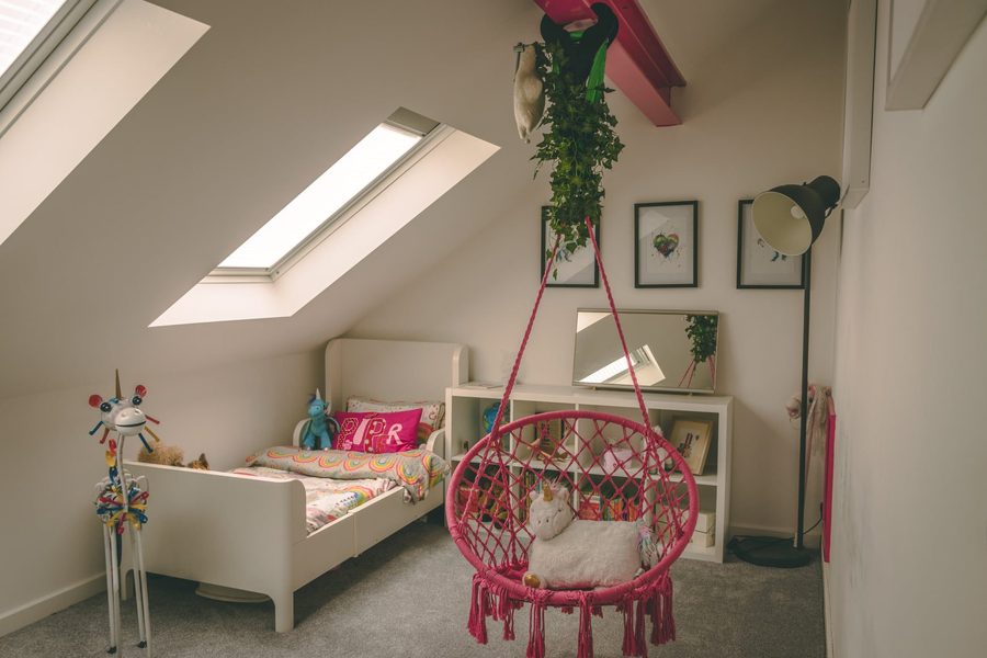 Child's loft bedroom with a Velux roof window, hanging chair and painted day bed